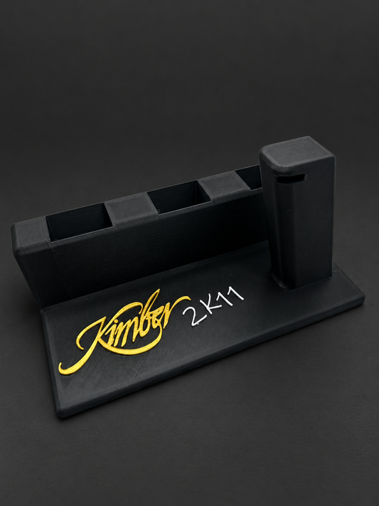 Kimber 2K11 Display Stand with 3 Magazine Slots, black polymer stand with gold and white markings on a charcoal background